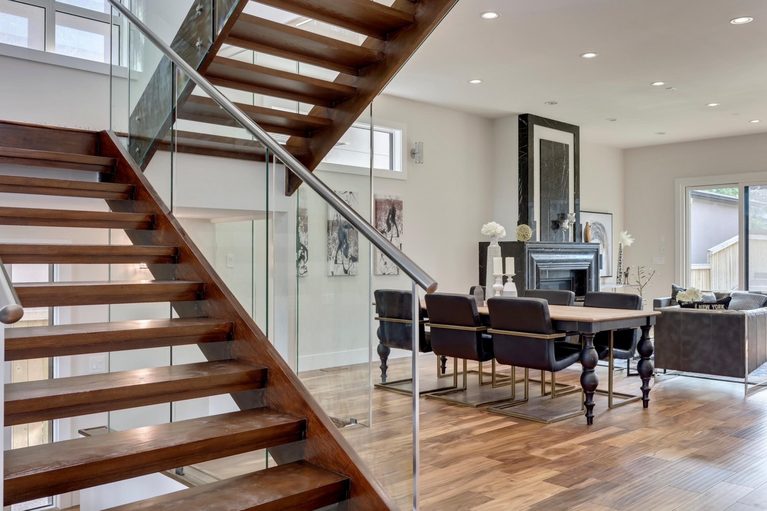 Killanery Custom Residence open-tread staircase with dining area and fireplace beyond