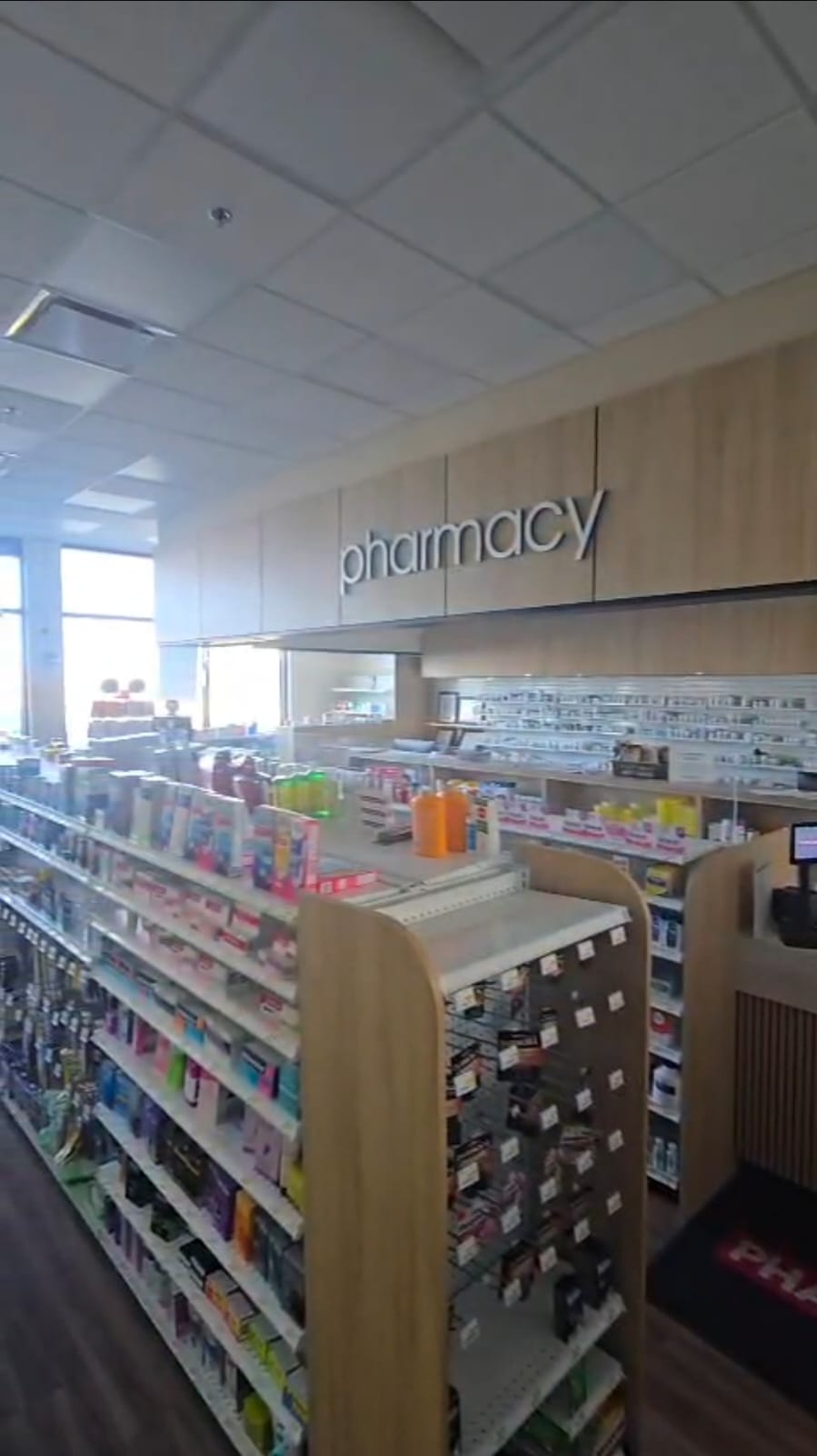 Pharmasave Sage Hill pharmacy interior with wood and black material palette